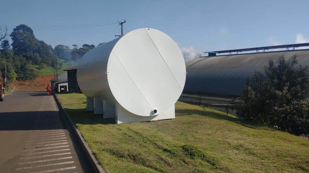 Tanque de Combustível horizontal aéreo em grama com pavilhão ao fundo
