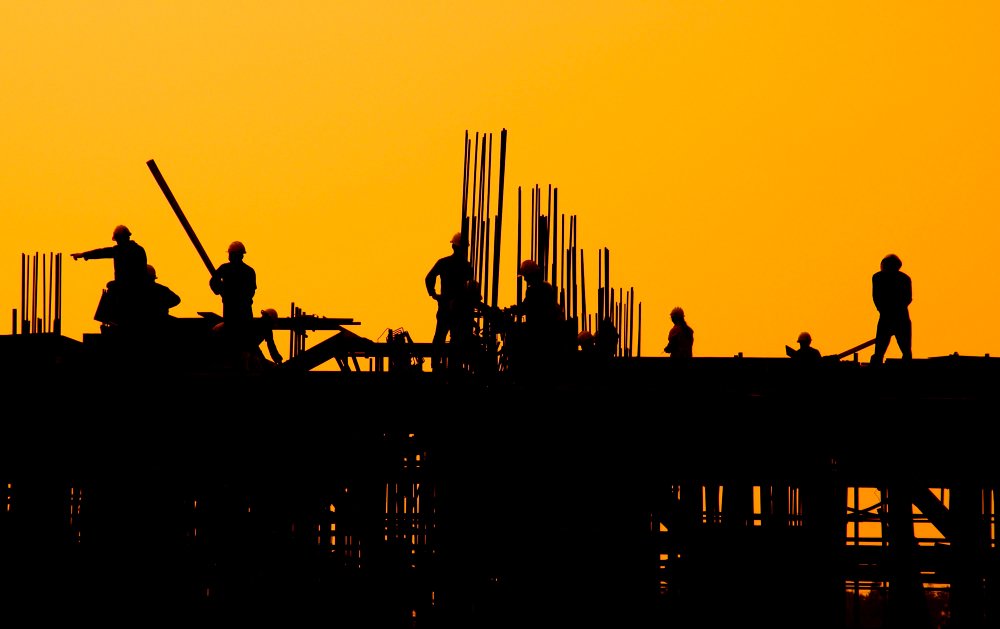 trabalhadores da construção civil em um canteiro de obras com reservatório para construção civil
