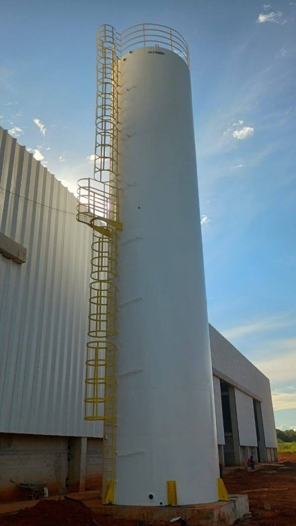 Imagem de caixa d'água tubular com pavilhão e céu ao fundo